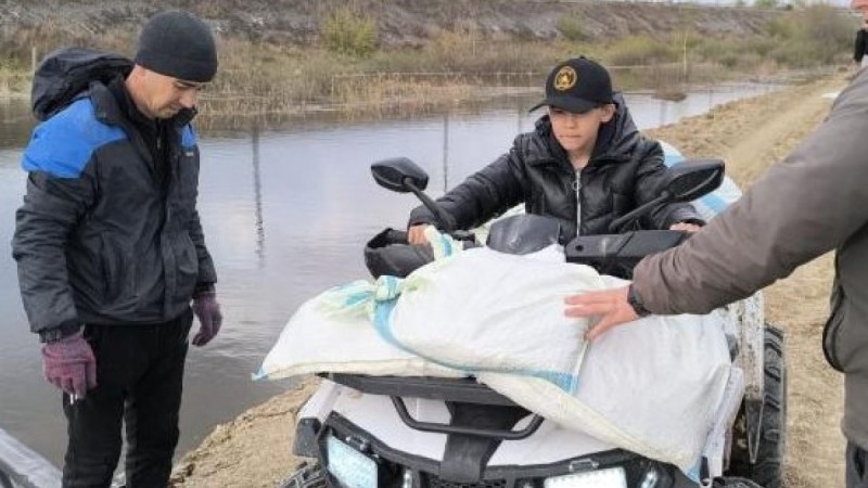 Большое сердце: мальчик на квадроцикле перевозит мешкотару для защиты дамбы
